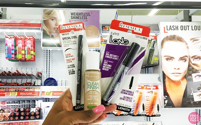 Hand Holding Rimmel Beauty Products in Front of a Store Shelf