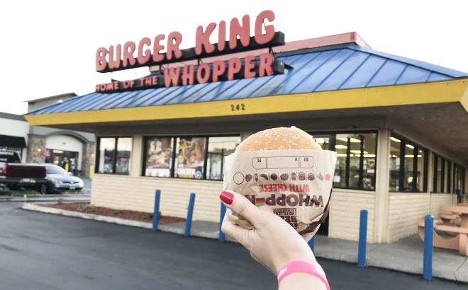 Hand Holding a Burker King Whopper in Front of the Store