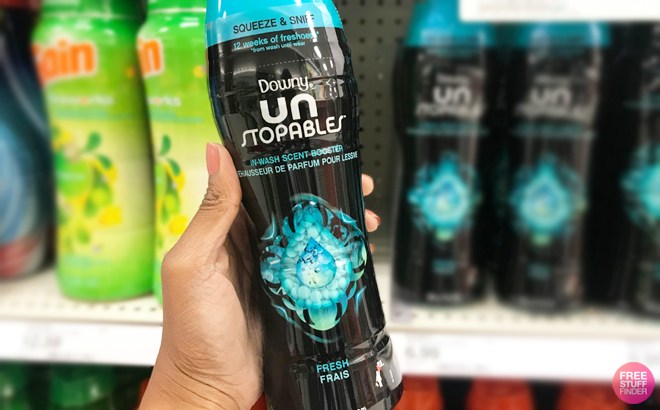 A Hand Holding Downy Unstoppables Fresh Scent Booster at a Store