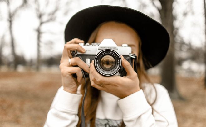 Girl Snapping a Shot with a Camera Taken by Professional Photographers