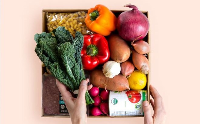 A Person Taking out Veggies from a Box A Person Taking out Veggies from a Box