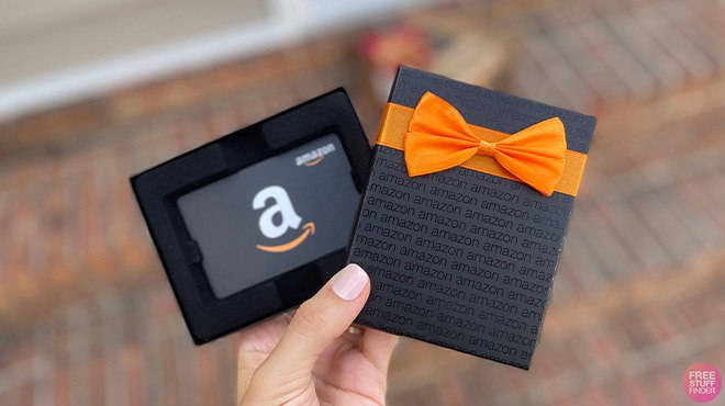 A Hand Holding an Amazon Gift Card in a Gift Box