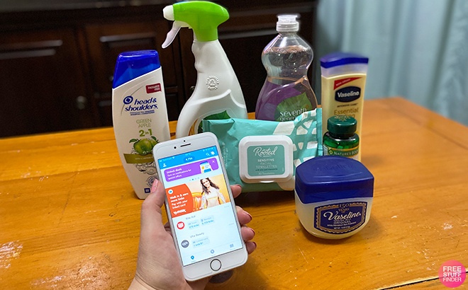 Hand Holding Phone with Shopkick App on It in front of Personal Care Items