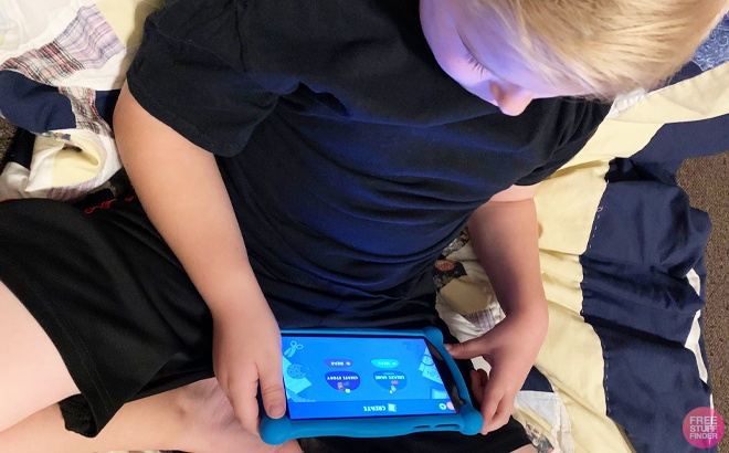Kid Sitting on a Couch Watching CodeSpark on a Tablet