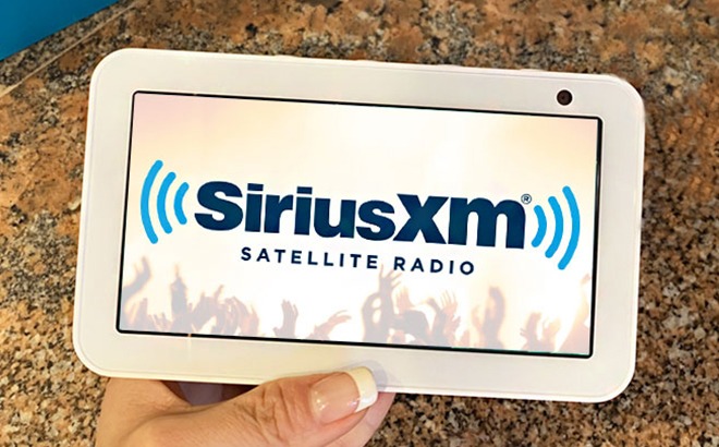 A Person Holding a Tablet with SiriusXM on the Background