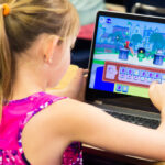 A Girl Using a CodeSpark App on a Laptop