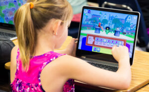 A Girl Using a CodeSpark App on a Laptop