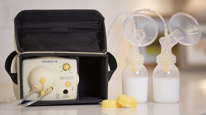 Opened Case with Breast Pump Inside next to Two Bottles of Milk
