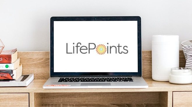 Laptop with LifePoints Logo on the Background on top of a Work Desk