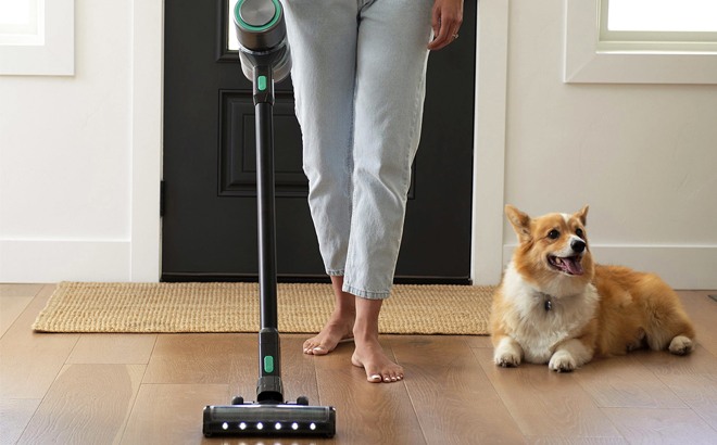 Woman Using Wyze Cordless Stick Vacuum Woman Using Wyze Cordless Stick Vacuum