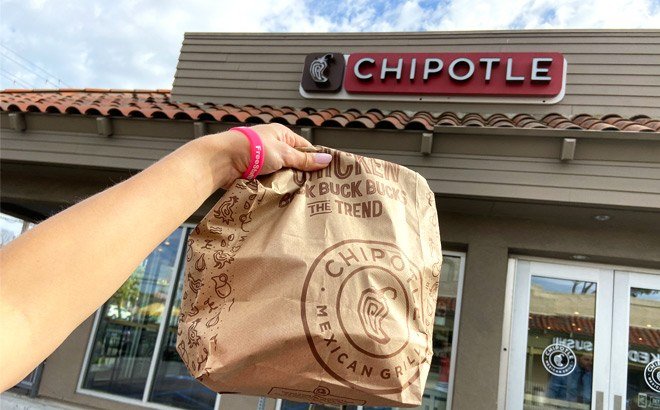 Handholding Chipotle Bag in Front of Chipotle Store