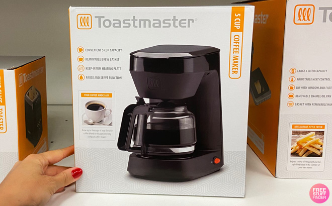 Hand Holding Toastmaster 5 Cup Coffee Maker on a Shelf