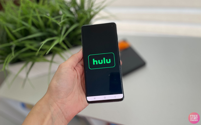 A Hand Hodling a Smartphone with the Hulu Logo on the Screen