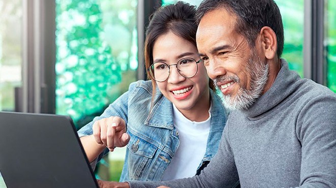 A Man and a Woman Looking at AARP Membership Perks on a Laptop and Smiling