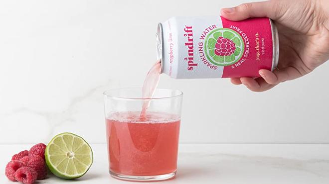 Hand Pouring Spindrift Sparkling Water in Raspberry Lime Flavor