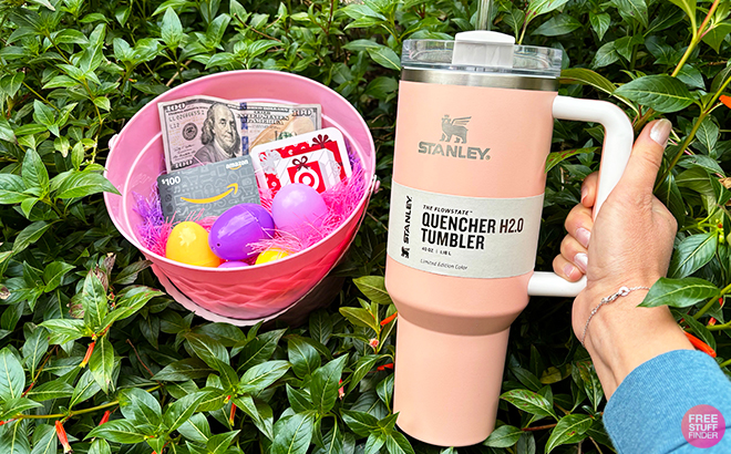 A Person Holding a Stanley Peach Quencher Tumbler with a Bowl Filled with Easter Eggs a 100 Dollar Bill and Target and Amazon Gift Cards (FSF Giveaway)