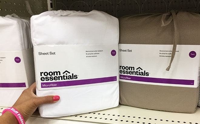 Hand Holding a Room Essentials Solid Sheet Set on a Store Shelf