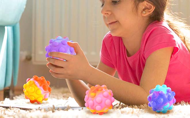 A Child Playing with a Pop It Ball Fidget Toy