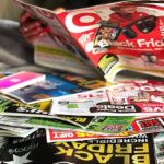 Holding a Target Black Friday Brochure with Other Retailers Brochures