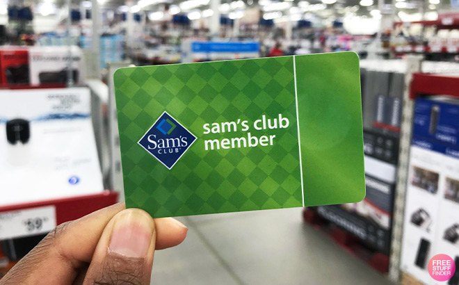 Hand Holding Sam's Club Membership Card in front on Aisles in Store