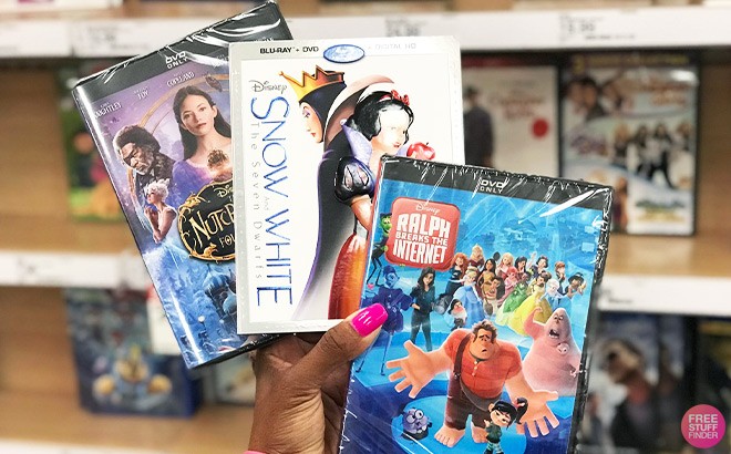 Hand Holding Disney Nutcracker, Snow White and Ralph Breaks The Internet Movie in Front of a Store Aisle