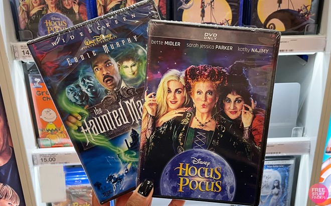 Hand Holding Disney The Haunted Mansion, and Hocus Pocus Movie in Front of a Store Aisle