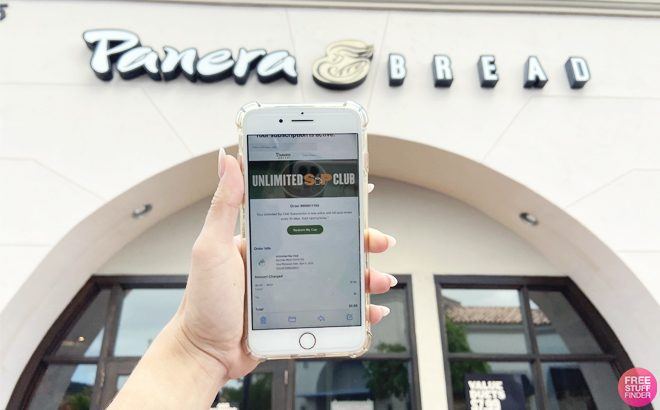 Hand Holding a Phone with Panera App on the Background at a Storefront