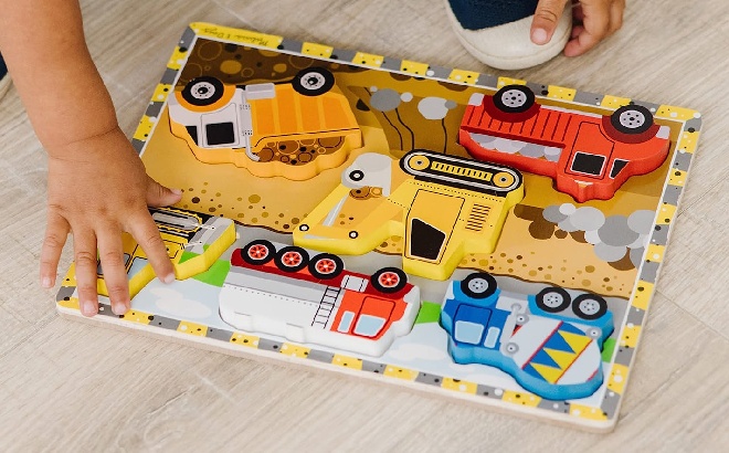 A Child Playing with the Melissa & Doug Construction Vehicles Wooden Puzzle