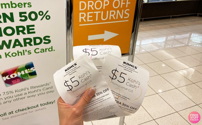 Hand Holding Three Kohl's Receipts for 5 Kohl's Cash in Front of a Drop Off Returns Sign at a Kohl's Store
