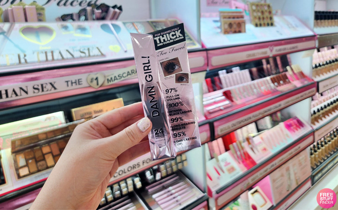A Hand Holding a Too Faced Mascara at a Store Aisle