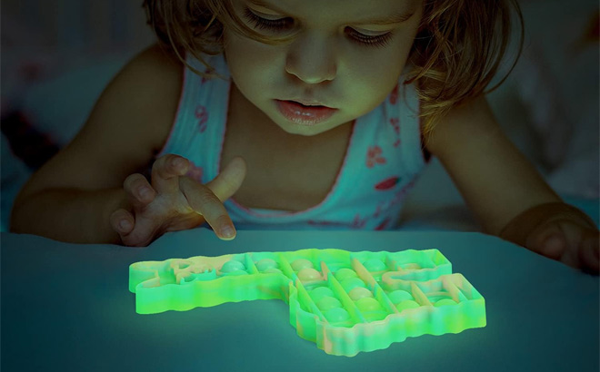 A Child Playing with a Glow in the Dark Pop It Toy