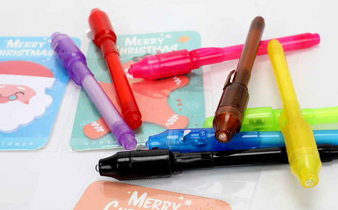 A Collection of Invisible Ink Pens with Christmas Cards on a Tabletop