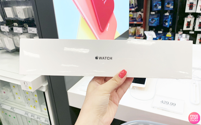 A Hand Holding an Apple Watch in a Store