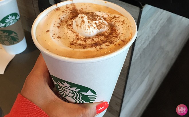 Hand holding Starbucks Pumpkin Spice Latte Drink