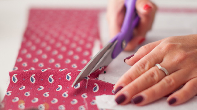 A Person Cutting a Piece of Red Fabric