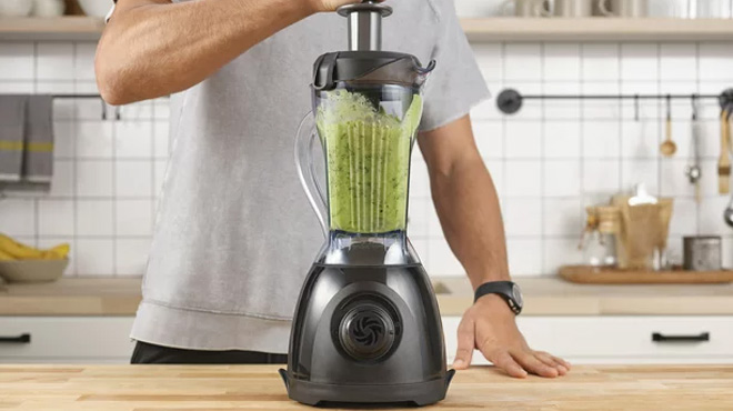 Man Using a Vitamix ONE Blender on a Table