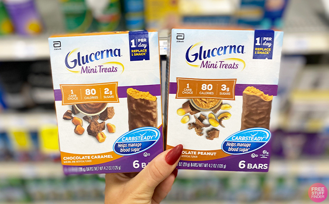 Hand Holding Two Boxes of Glucerna Mini Treats Snack Bars 6 Count