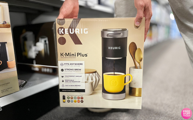 Man Holding Keurig K-Mini Plus Coffee Maker in a Box