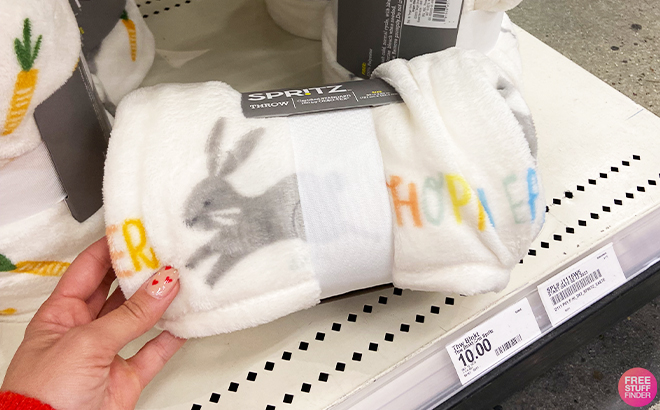 Spritz Hoppy Easter Throw Blanket on a Shelf