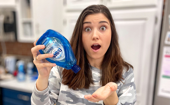 woman holding empty dawn powerwash refill bottle upside down