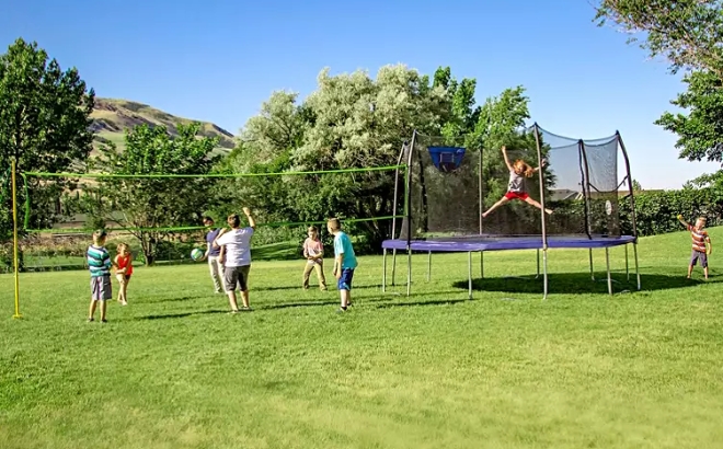 A Family Playing on the Skywalker Round Sports Arena with Trampoline and Enclosure