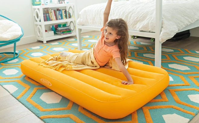 A Girl Laying on the Intex Cozy Kidz Inflatable Airbed in Orange
