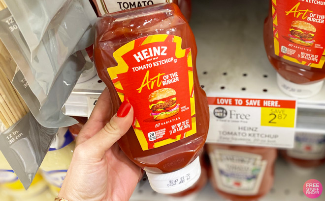 A Hand Holding Heinz Tomato Ketchup in Front of a Shelf in Publix