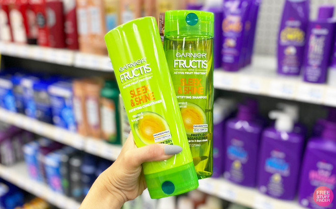 A Hand Holding Two Garnier Fructis Hair Care Products