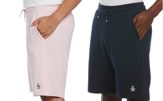 A Men Wearing the Original Penguin Fleece Shorts in Light Pink on the Left and Dark Navy on the Right