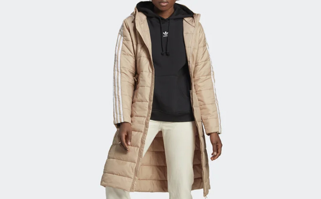 A Model Wearing Adidas Womens Hooded Premium Long Slim Jacket in Magic Beige Color