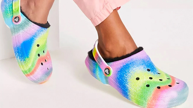 A Model Wearing Crocs Classic Fur Lined Spray Dye Clogs in White Multi Color