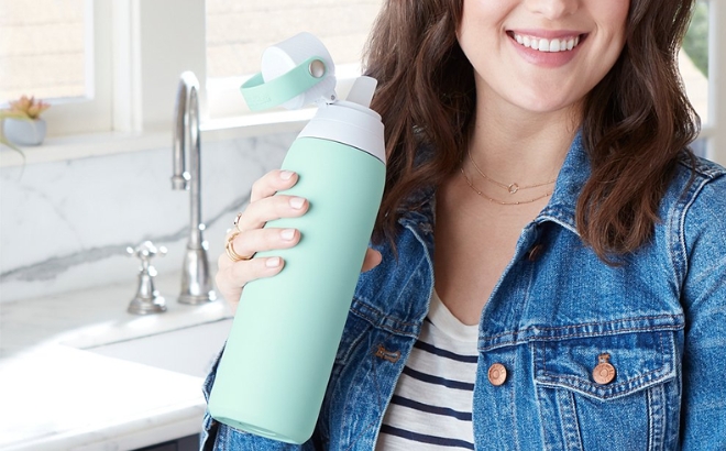 A Woman Holding the Brita Filtering 20 Ounce Water Bottle in Glaciar