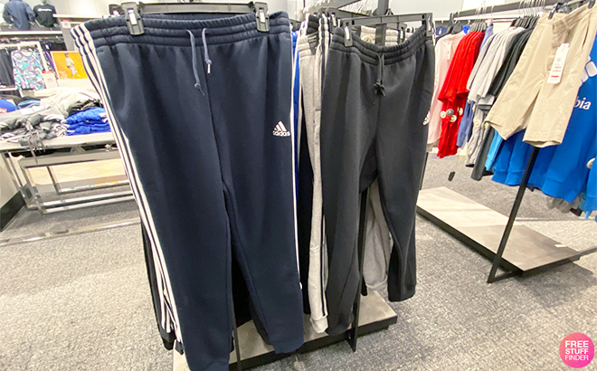 Adidas Three Stripes Fleece Joggers in Black and Blue on a Rack