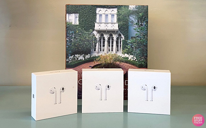 Apple Airpods 2nd Generation in Boxes on a Table with a Picture in the Background